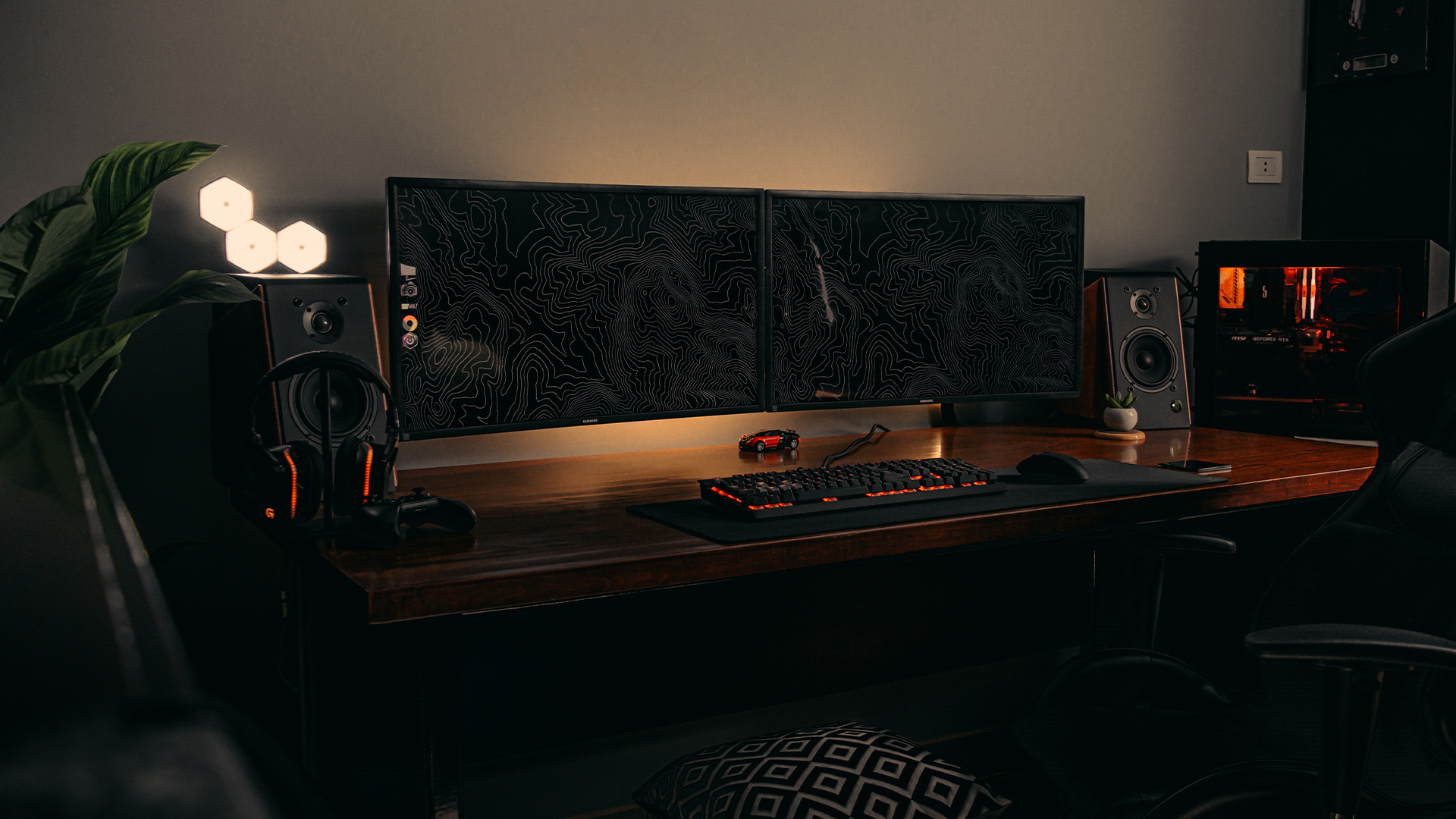 gaming desk with two monitors, keyboard and lighting